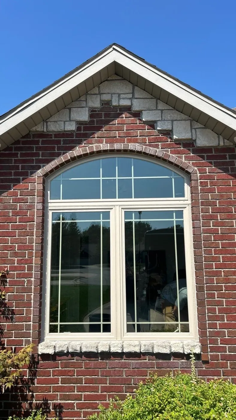 After: the finished arched window gives the exterior a cleaner architectural focal point.
